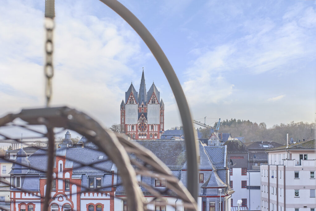 Balkon mit Domblick – Entspannen im Hängesessel oder bei einem Essen im Freien
Der möblierte Balkon unserer Ferienwohnung in Limburg bietet einen traumhaften Blick auf den Dom. Ein bequemer Hängesessel und eine stilvolle Essgarnitur laden dazu ein, den Ausblick in vollen Zügen zu genießen.