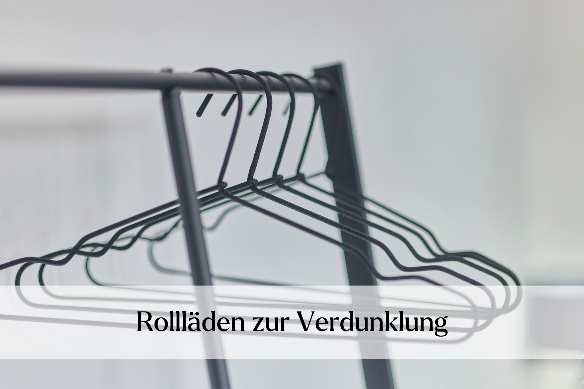 Kleiderständer mit Bügeln im Schlafzimmerbereich und Hinweis zu Rolläden zur verdunklung der Ferienwohnung